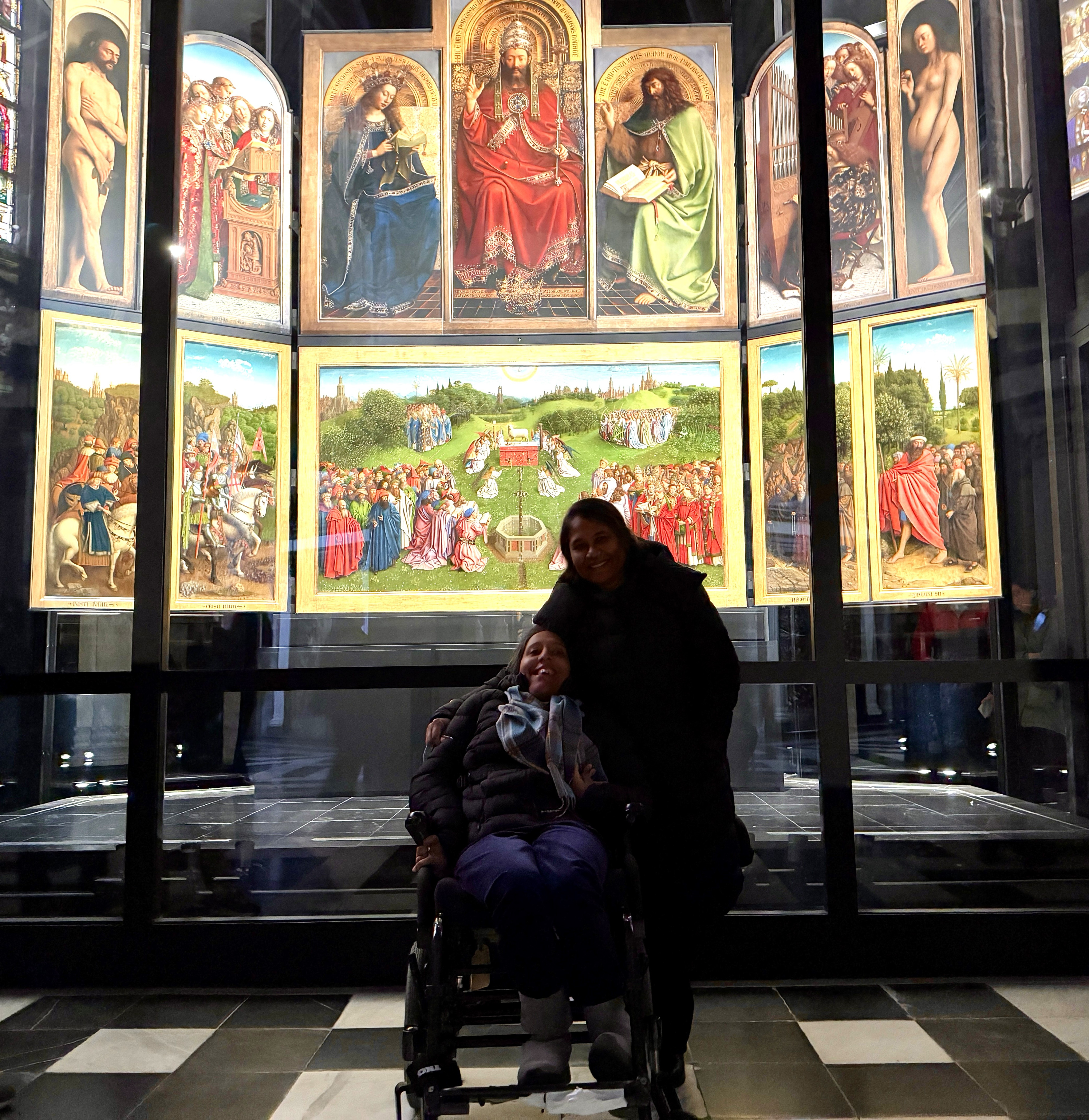 Annie posiert mit ihrer Verwandten vor den Tafeln der „Anbetung des Lamm Gottes“ im Besucherzentrum der St.-Bavo-Kathedrale in Gent. 